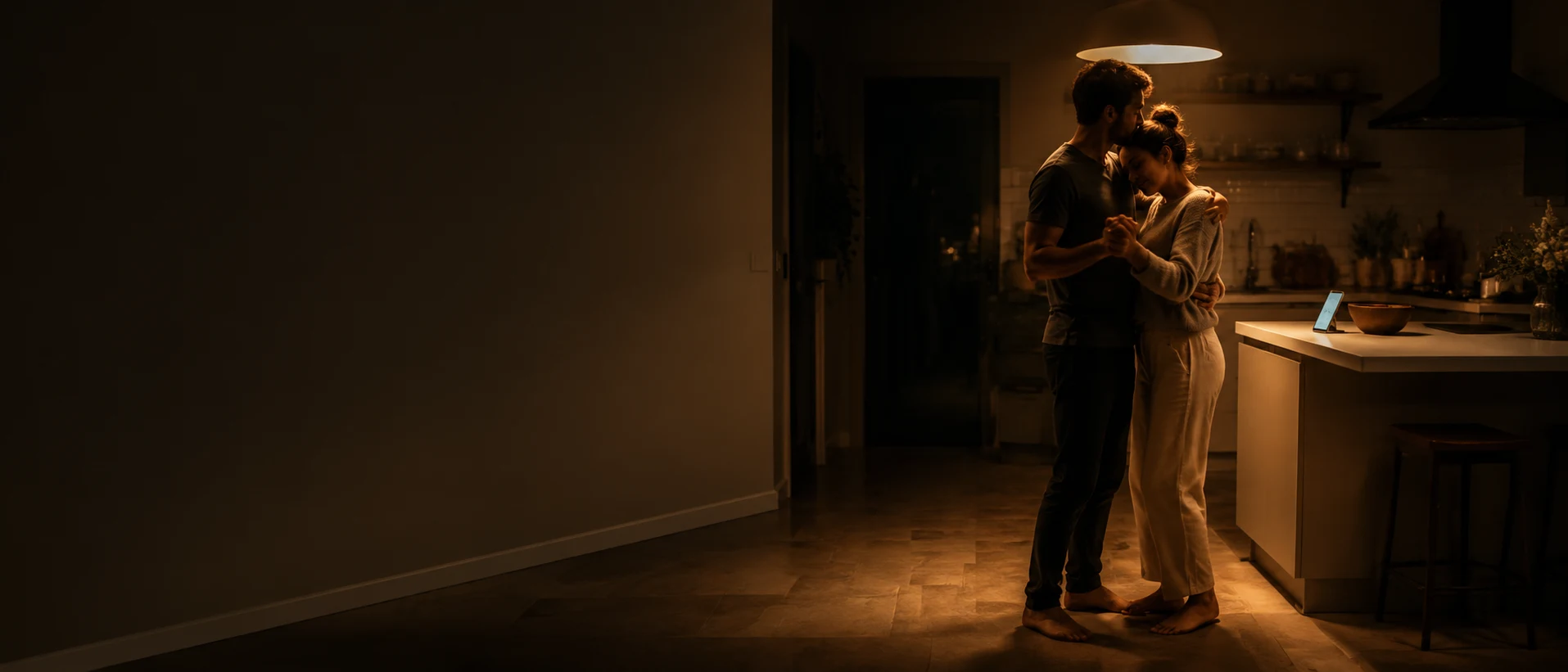 Couple dancing in a kitchen while a personalized song plays from a phone on the counter